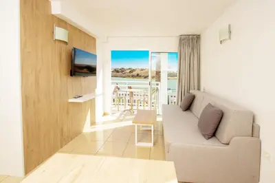 Una televisión o centro de entretenimiento en Apartamentos Cocoteros