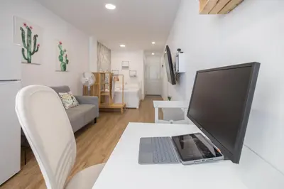 Una televisión o centro de entretenimiento en Las Canteras Beach Workfriendly Bright Studio
