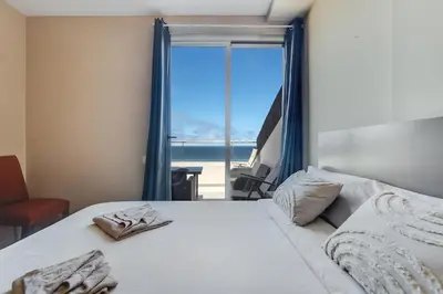 Cama o camas de una habitación en Spacious Two Bedroom Apartment with Terrace right on the Surf Beach