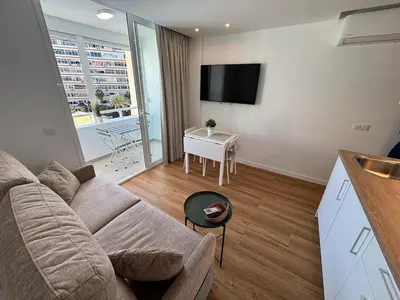 Una televisión o centro de entretenimiento en Modern apartment with pool and balcony
