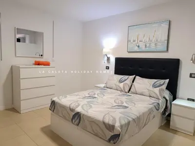 Cama o camas de una habitación en La Caleta Holiday Homes