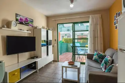 Una televisión o centro de entretenimiento en Bungalow DUNA FLOR VERDE Maspalomas