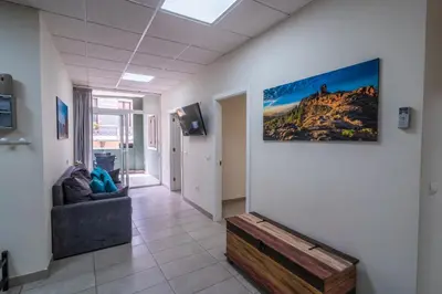 Una televisión o centro de entretenimiento en El Puente Holiday Home -Airport