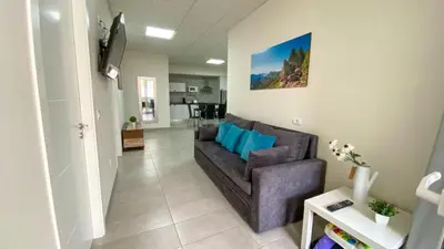 Una televisión o centro de entretenimiento en El Puente Holiday Home -Airport