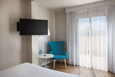 Una televisión o centro de entretenimiento en NH Las Palmas Playa las Canteras