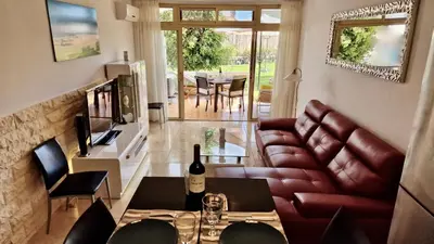 Una televisión o centro de entretenimiento en Tamaran 102 - Luxury Garden Apartment